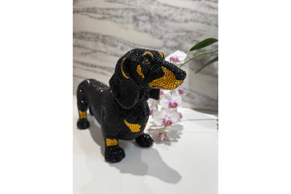 Black and gold dog figurine on a white surface with a marble background