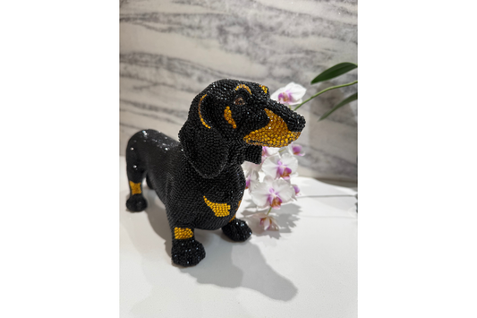 Black and gold dog figurine on a white surface with a marble background