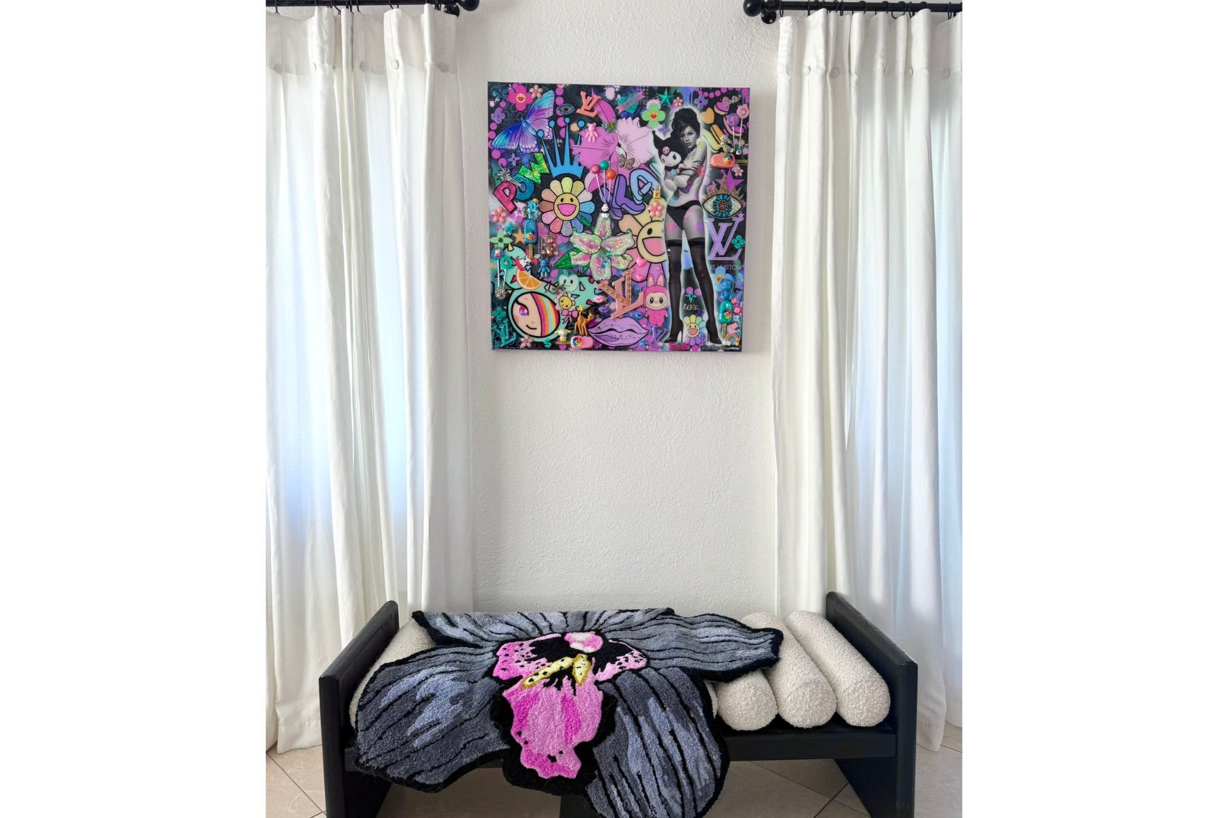 Colorful abstract painting on a wall above a bench with a blanket and stuffed animals.